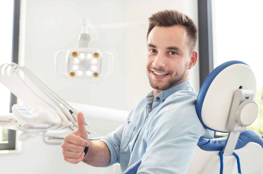 Handsome,Man,Showing,Thumbs,Up,And,Smiling,Sitting,At,The