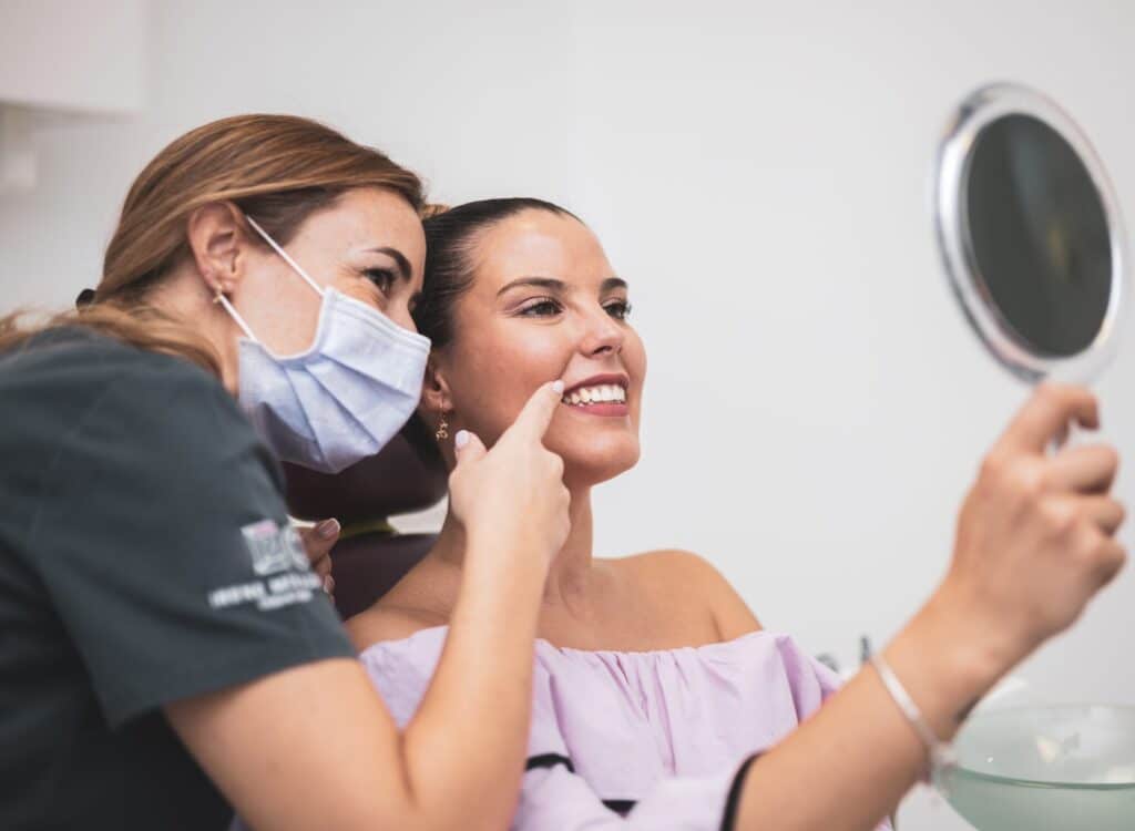 The,Woman,Looks,At,Her,Smile,With,A,Mirror,In